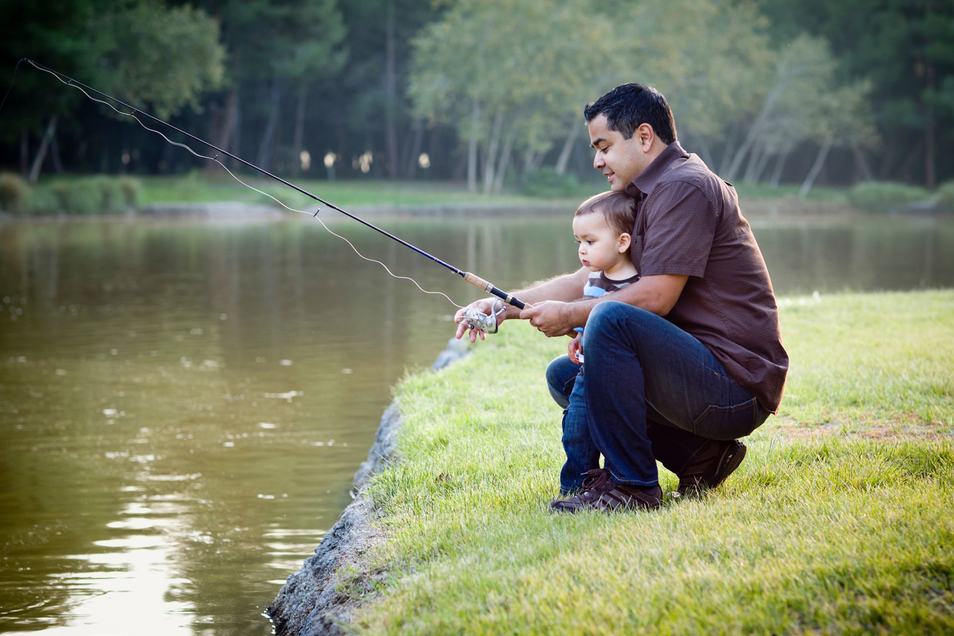 Father and young son fishing in the evening.