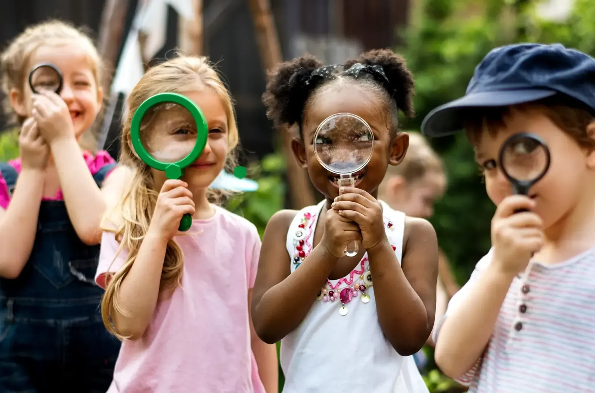 Group of little kids with magnifying glasses.