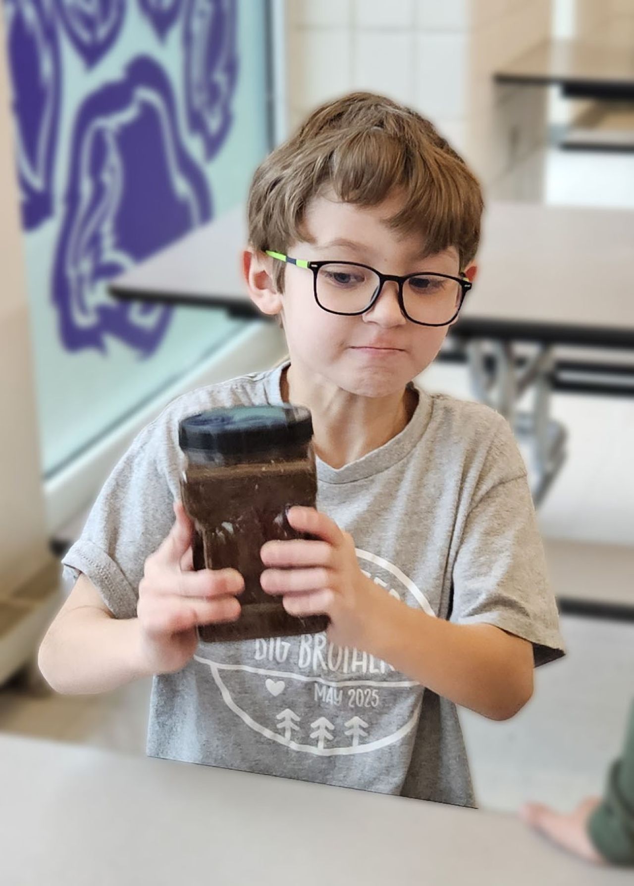 School Age boy holds canister during activity.