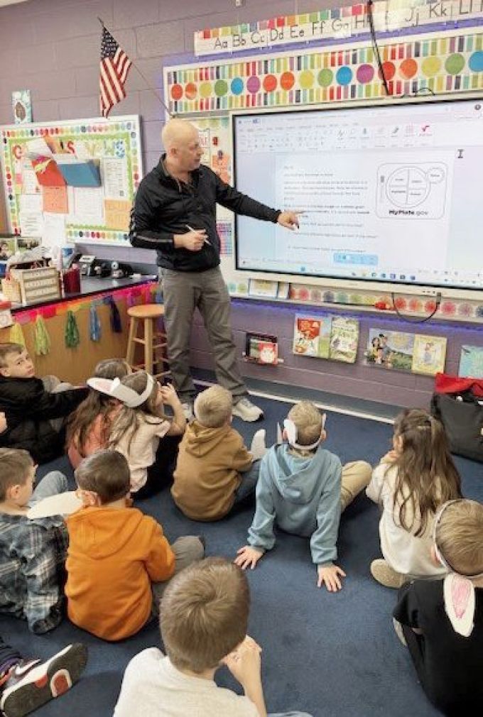 Matt Bugaj at front of classroom with Smartboard.