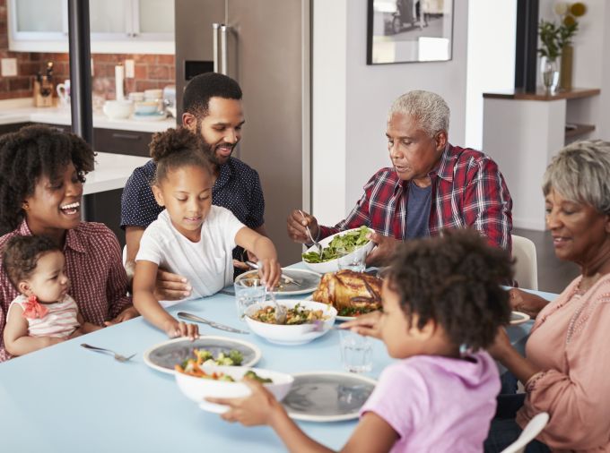 Multi-Generation Family Enjoying Meal Around Table At Home